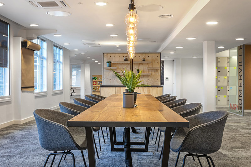 Example of flexible office space conference room with large wood table and blue chairs